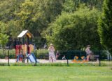 Istniejący plac zabaw dla dzieci w Dolinie Trzech Stawów w Katowicach — zestaw ze zjeżdżalnią i kiwaki, w tle zieleń parkowa