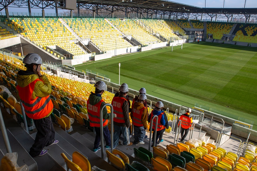 Uczniowie w kaskach podczas wizyty studyjnej na stadionie w ramach programu Katowice Miastem Fachowców